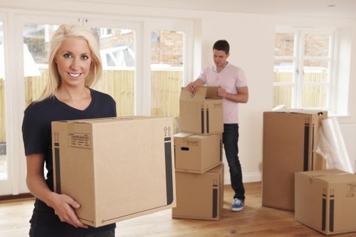 Trained removals staff carrying furniture with care in a hallway