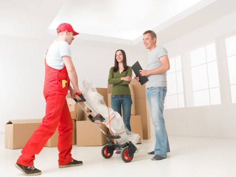 A local removal team navigating a Westealing street with a moving van